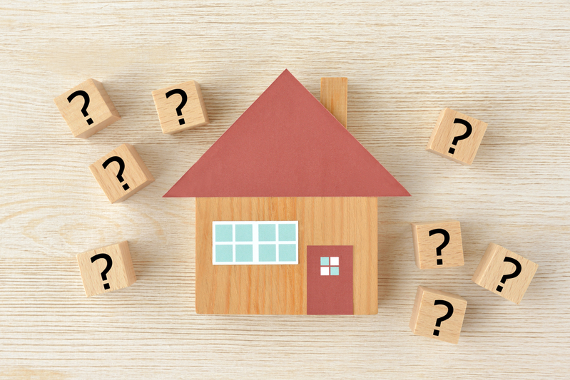 model of house surrounded by blocks with question marks