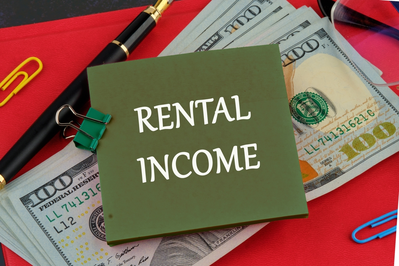 note that says Rental Income on stack of $100 bills