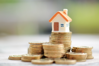 mini house on stack of coins