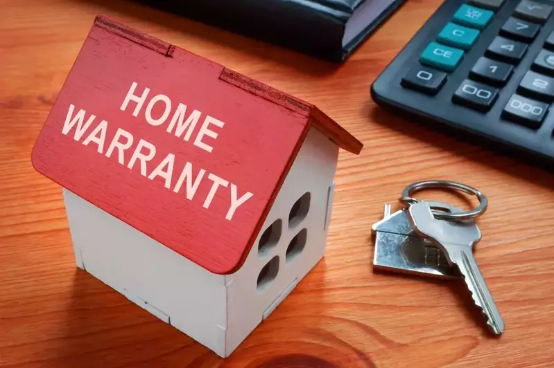 house key next to model of house with inscription Home Warranty on roof