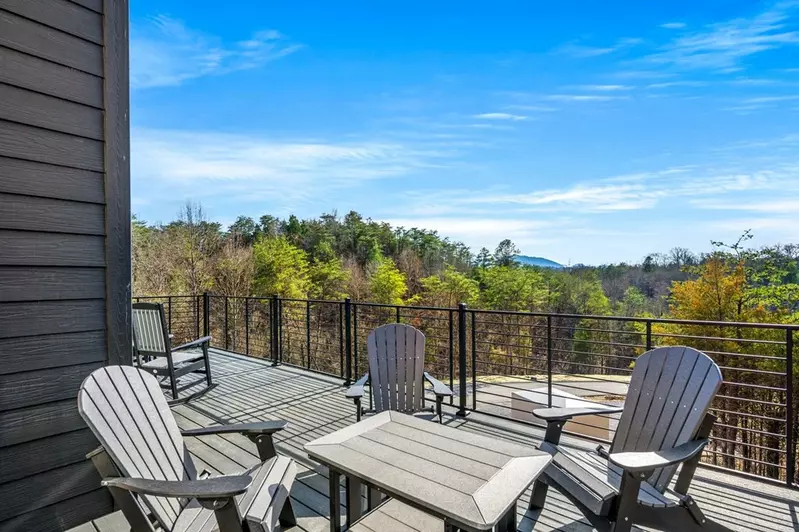deck with table and chairs in front of mountain view