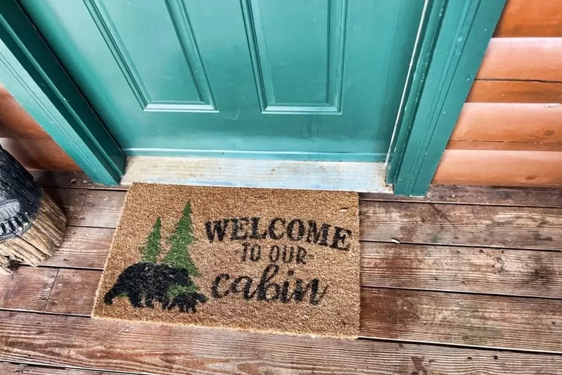welcome mat at door that reads WELCOME TO OUR CABIN