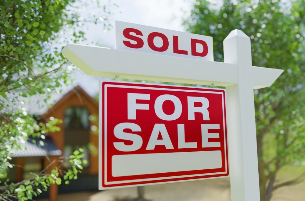 Sold For Sale sign in front of cabin